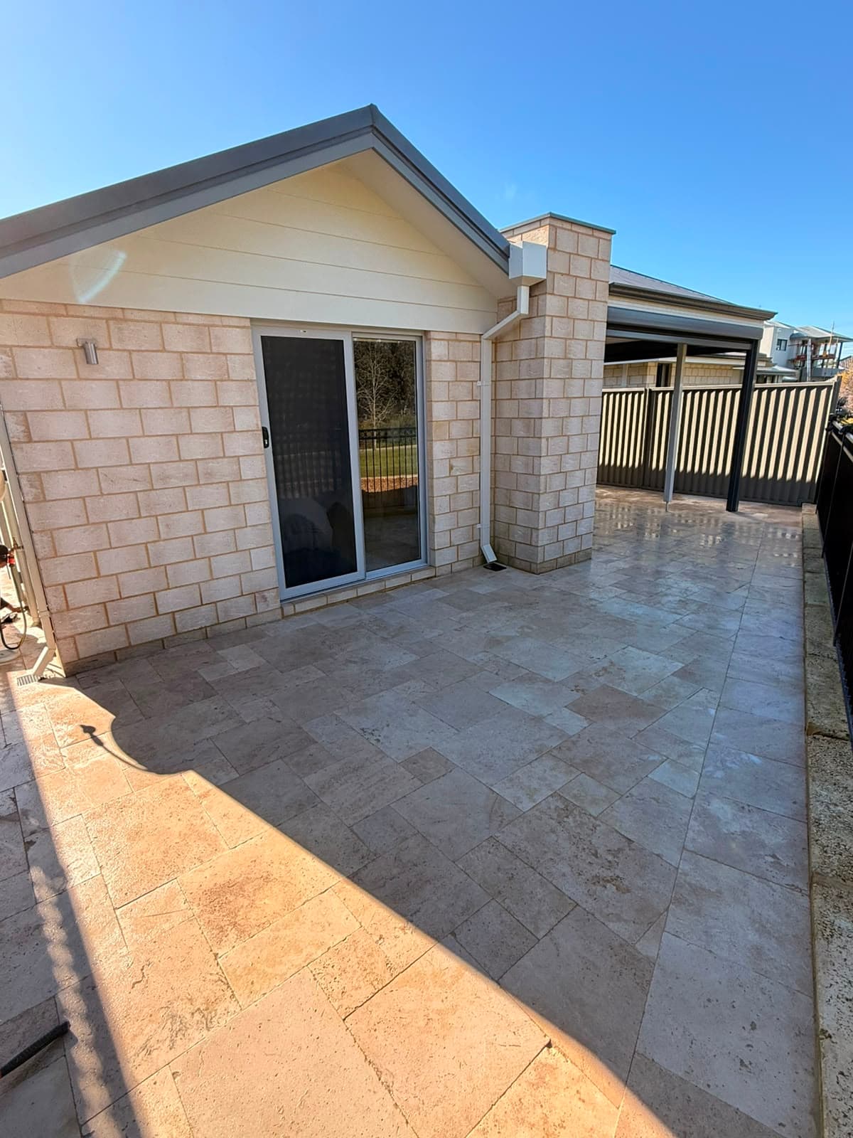 Travertine paving laid across a backyard entertaining area, Perth